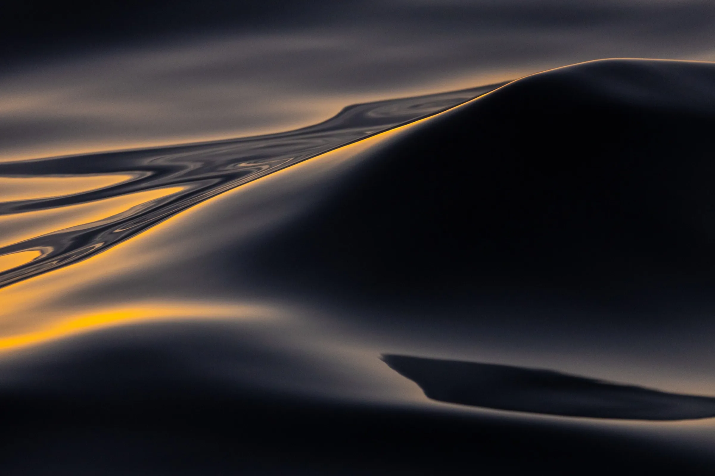 A streak of gold evening light across dark, calm water