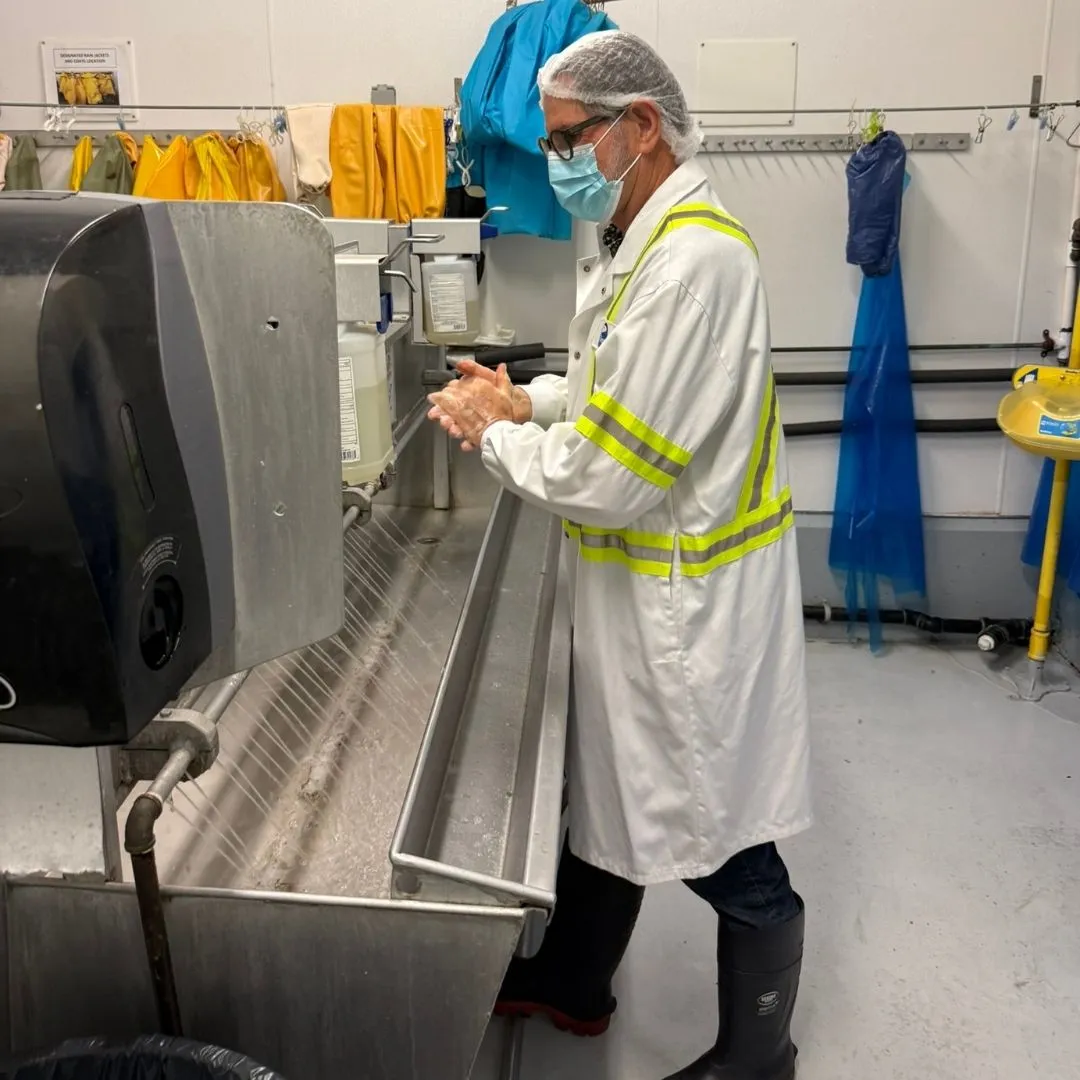A team member washing hands at the hand-washing station before entering the plant floor
