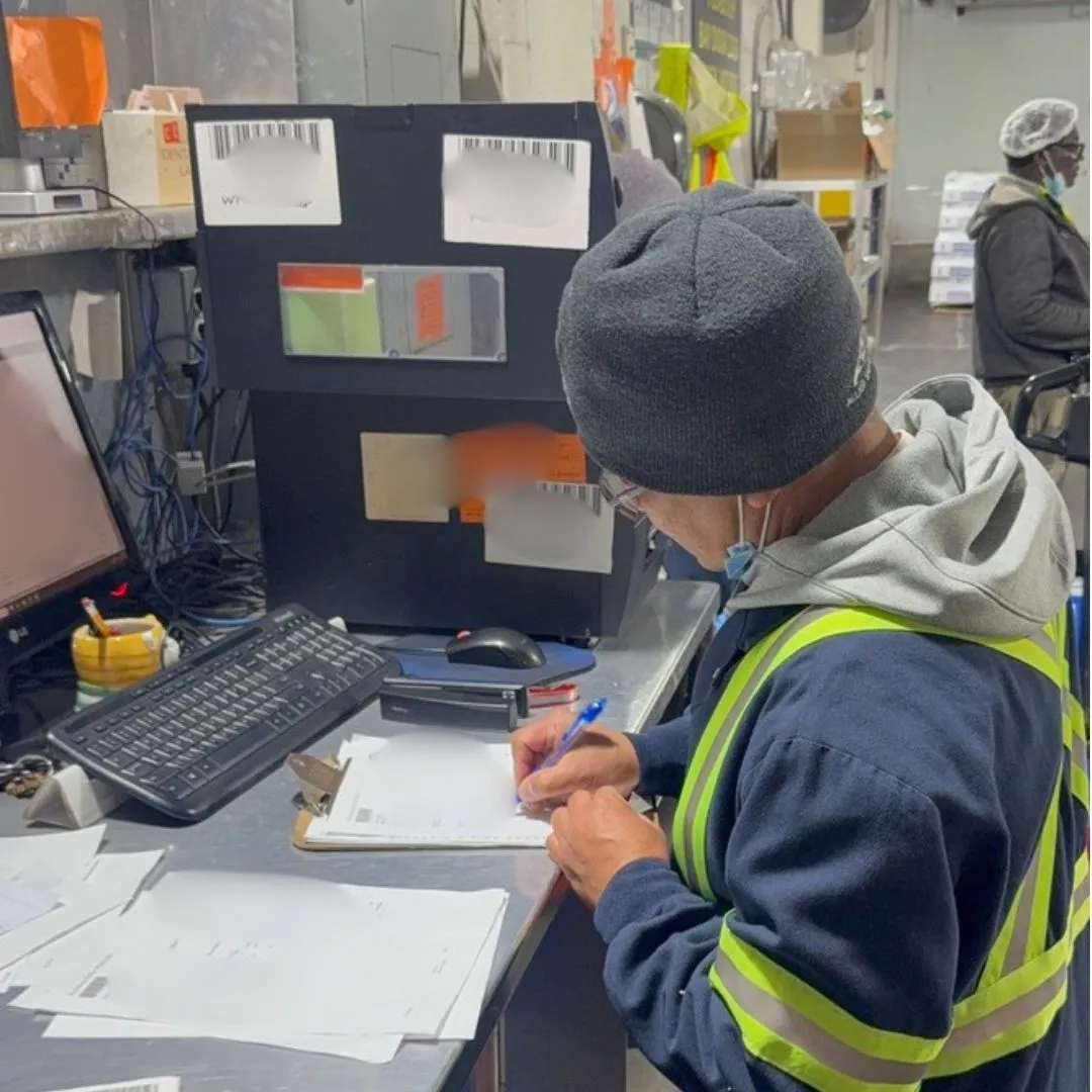 A receiver working through paperwork at the receiving desk