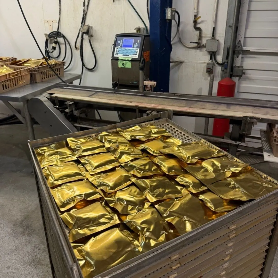 Vacuum-packed and labelled retort pouches racked for the pressure cooker