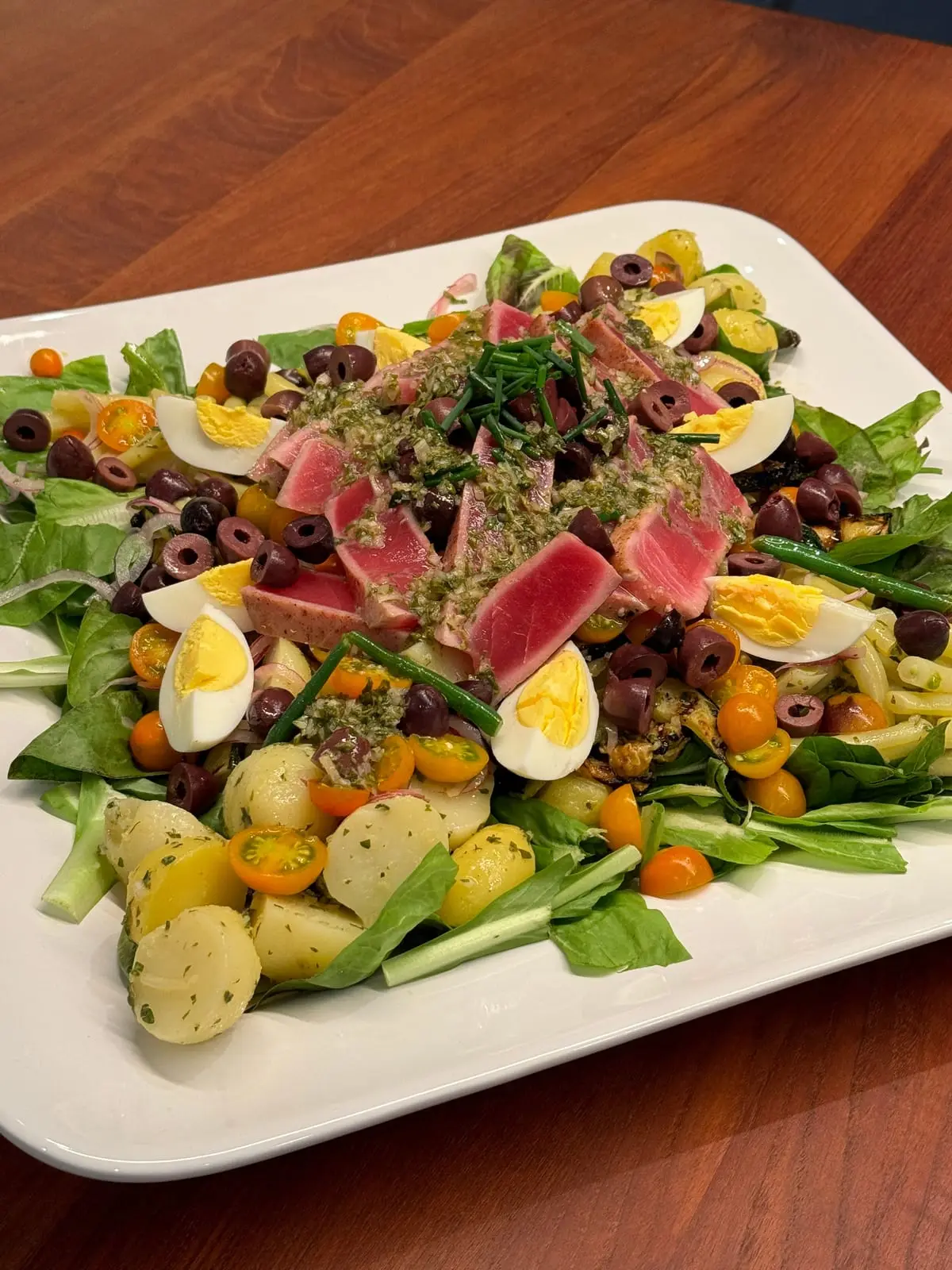 A Niçoise salad topped with slices of seared rare tuna