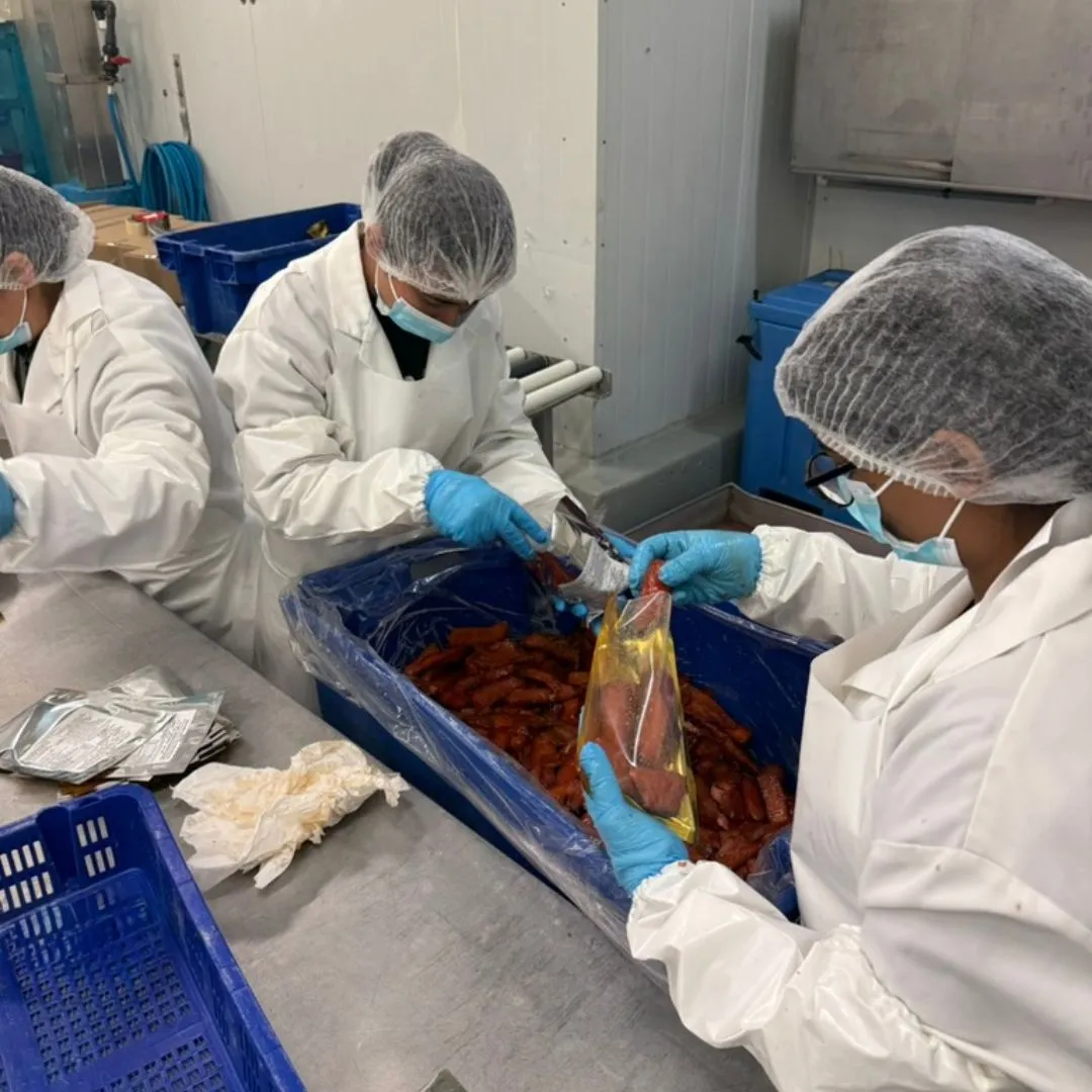 Bagging smoked salmon candy into gold retail pouches