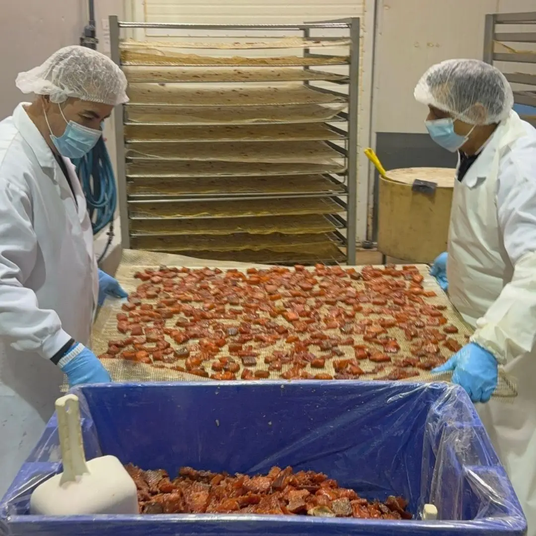 De-racking freshly smoked salmon candy before packaging