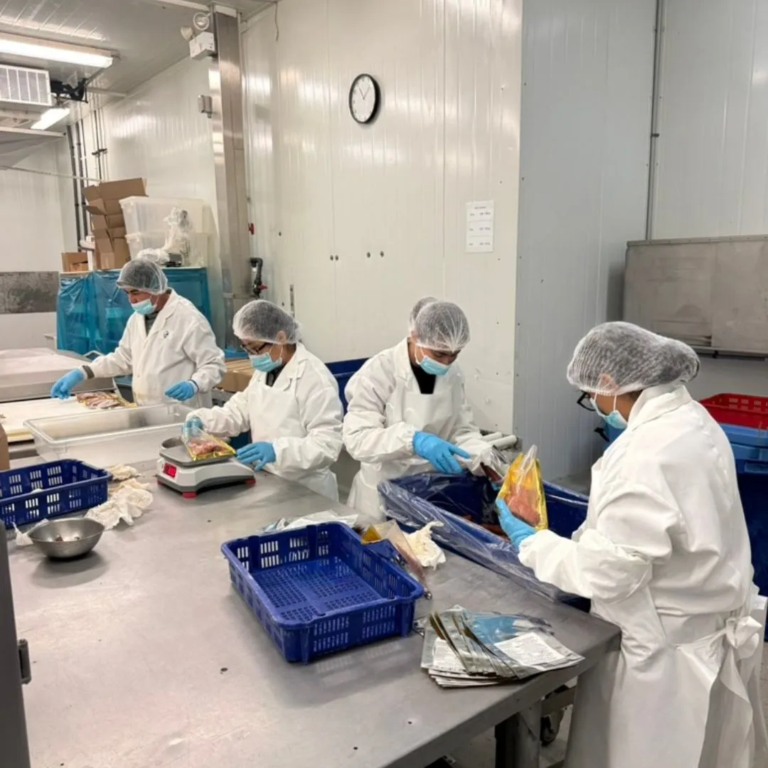 The team weighing and packing smoked salmon candy at the packing table