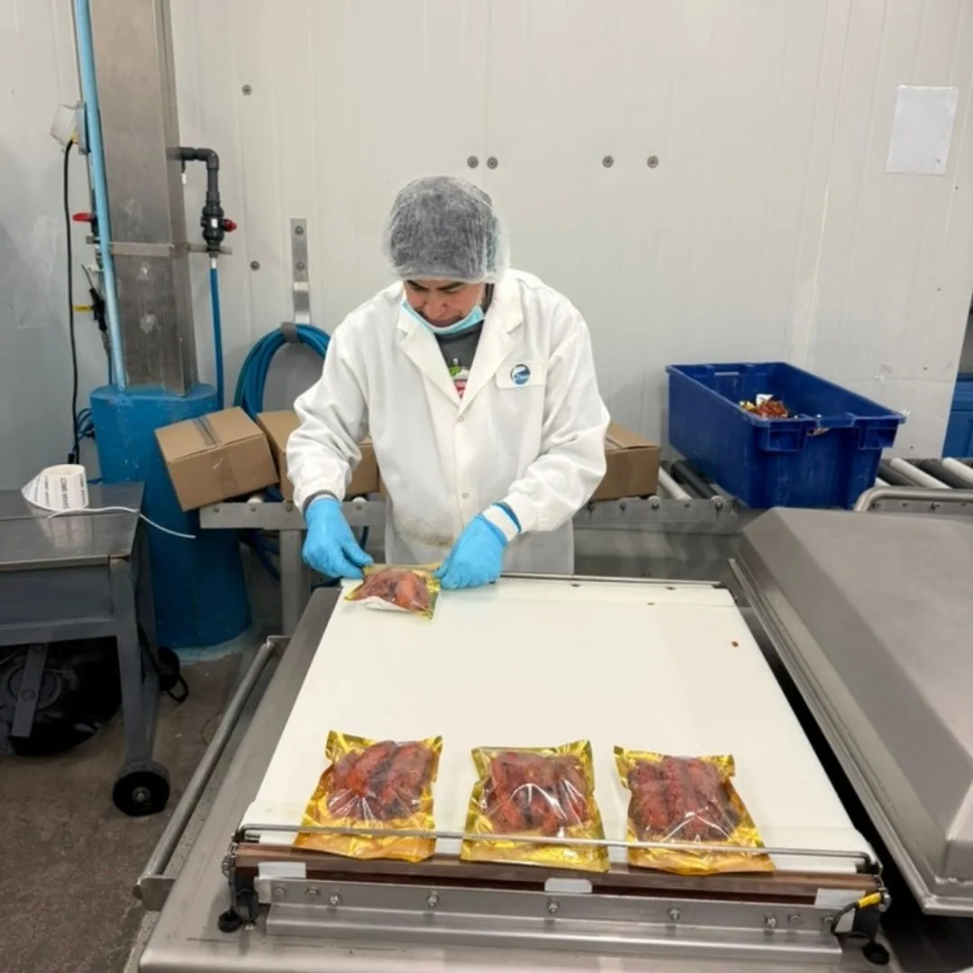 Team member vacuum-sealing pouches of smoked salmon candy