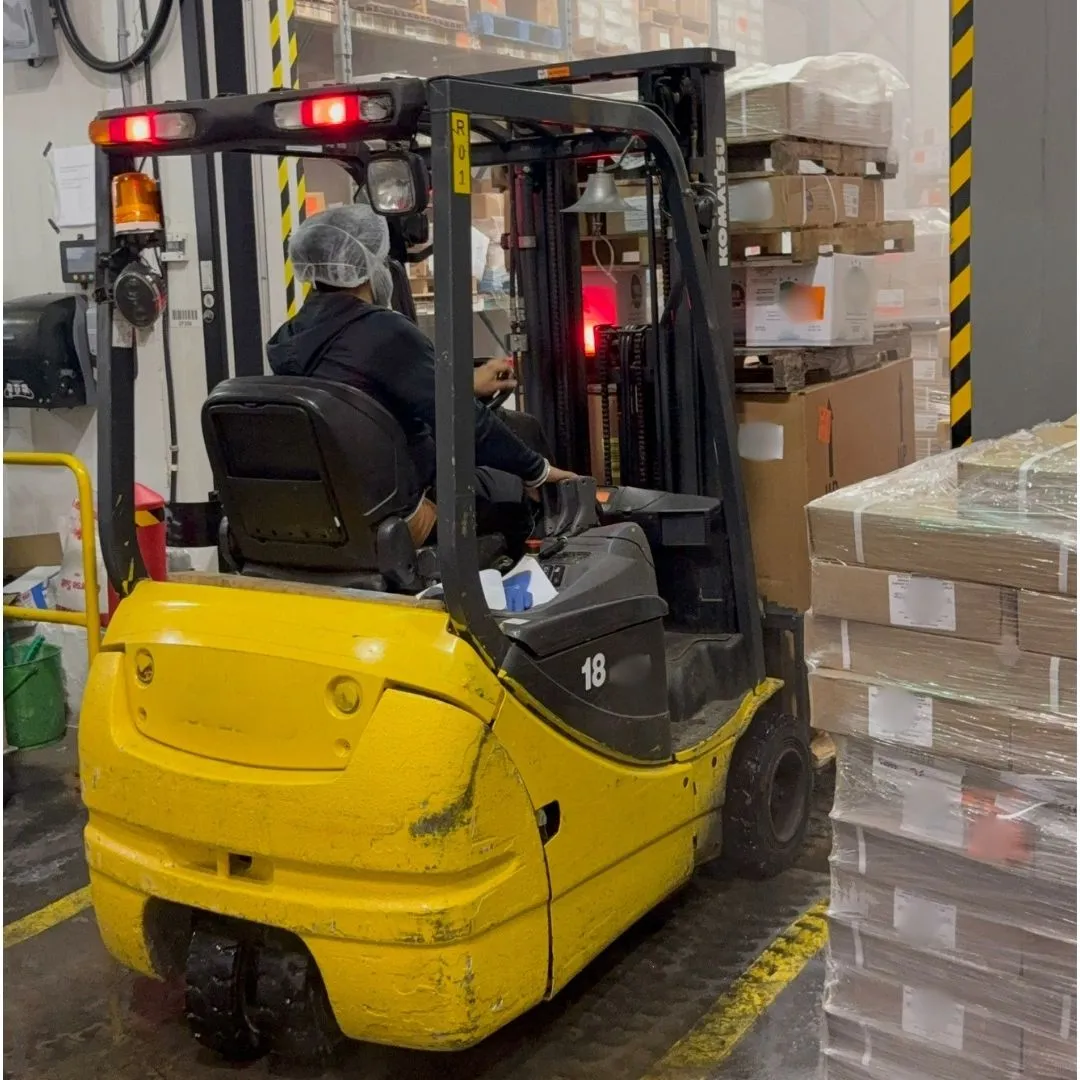 Forklift loading a wrapped pallet into the freezer