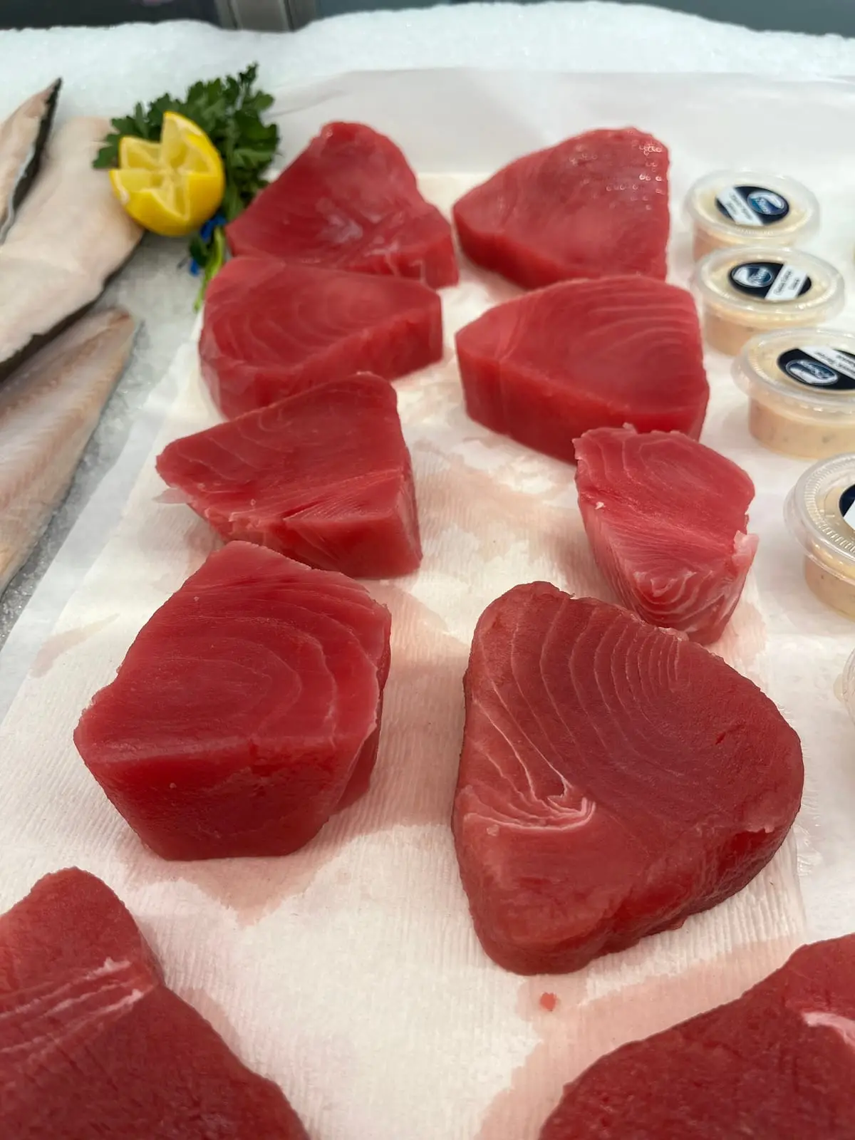 Thick-cut yellowfin (ahi) tuna steaks, deep red, on ice